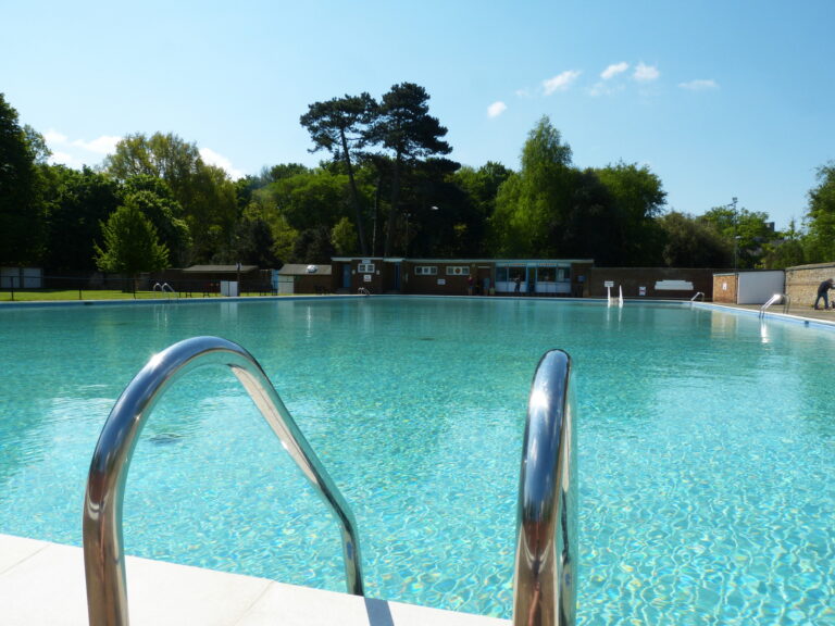 Pells Pool, Lewes: turquoise spring-fed lido, metal ladder, trees over the changing rooms