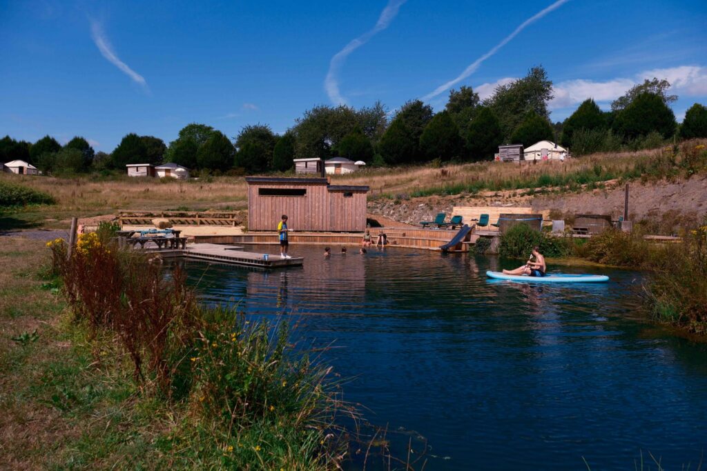 Yurts beside the spring-fed swimming lake at Walnut Farm Glamping in Dorset, with wild swimming on site